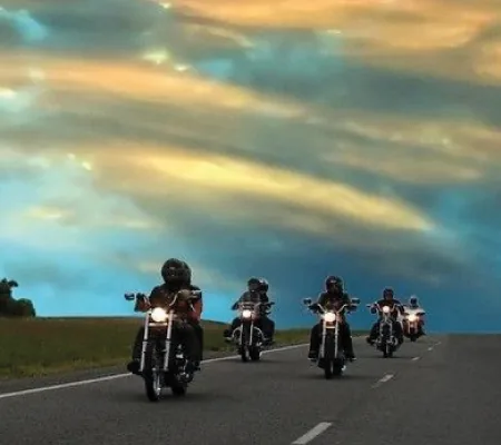 Grupo de moteros rodando al atardecer